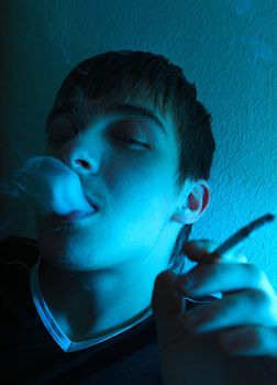 Portrait of Smoking Young Man in the Deep Blue light