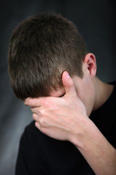 Sad Young Man On the Black Background hide his Face