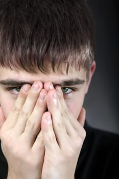 Portrait of Sorrowful Young Man on the Black Background Closeup