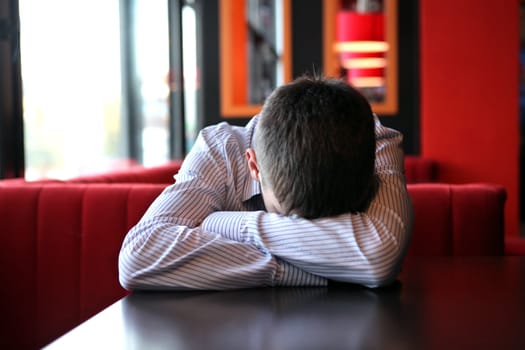 Tired Young Man sleeps on the table at the Home