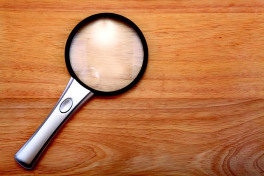 Magnifying glass lying on the wooden table