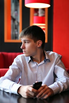 Young Man with Mobile Phone waiting for someone at the Home