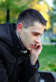 Young Man Talking On Mobile Phone at the Park
