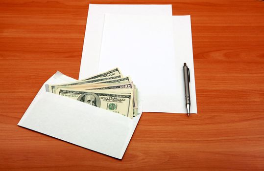 Envelope with a Money and Empty Paper for Text on the Wooden Table