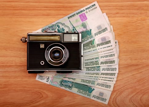 Vintage Camera And Russian Currency on the Wooden Background