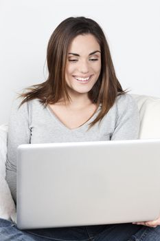 Young beautiful woman using laptop on sofa