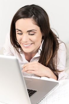 Portrait of beautiful woman using laptop on bed