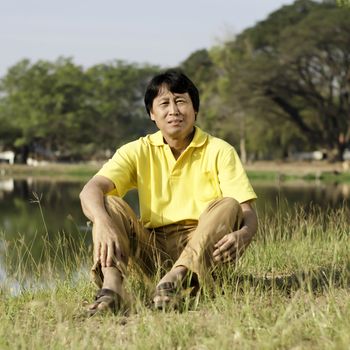 Happy asian middle-aged man in the park 