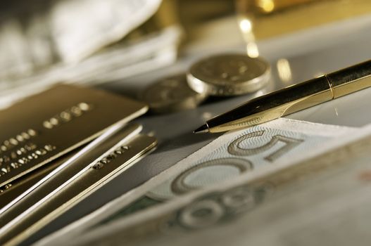 credit card, coins, banknote and gold pen. (The depth of the field is low.)