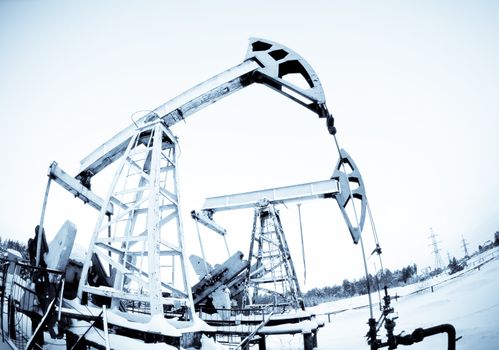 two oil pump on the field, frosty winter day. selenium tone.