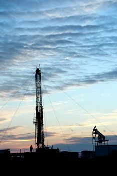 Drilling Rig at sunset sky background. Oil fields in Western Siberia