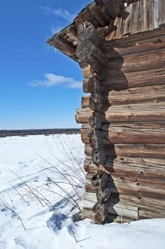 Village outskirts and corner of old log barn, winter sunny day