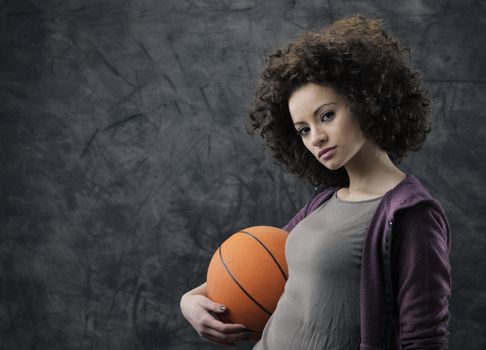 Portrait of young beautiful woman holding a basketball