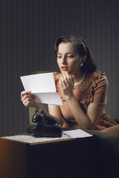 Young woman reading a letter sitting on armchair