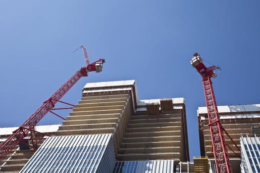 High-rise construction cranes and unfinished office