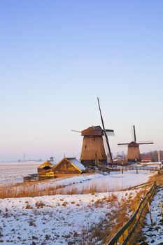 Windmill in winter time with snow and blue sky