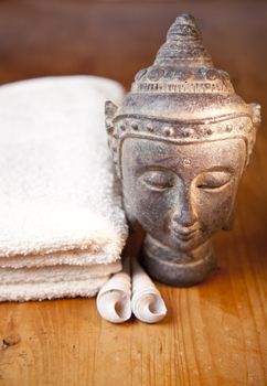 Luxury bath or shower set with towel, buddha and shells on wooden table