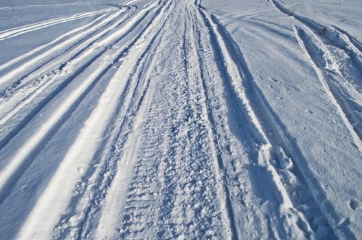 Close up of snowmobile trail, winter sunny day