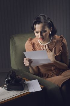 Young woman reading a letter with worried expression