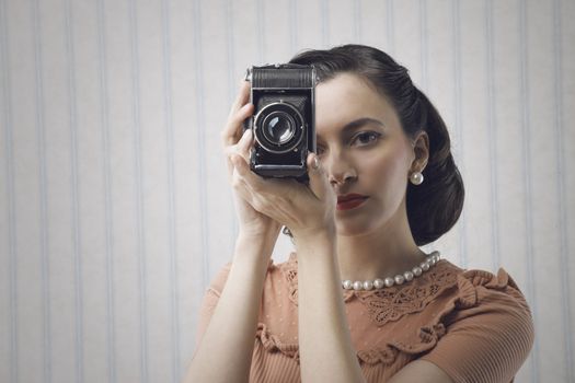 Beautiful young woman with a old camera