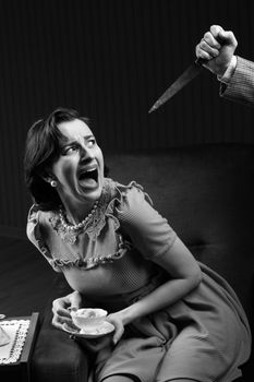 Terrified woman by a man murderess with a knife. Classic film noir style