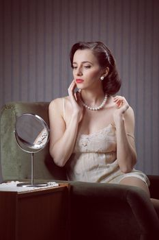 Young woman examining make-up in mirror
