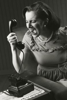 Angry woman screaming at retro phone, 1950 style 