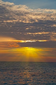 Bright beams of a rising sun over the sea, Thailand