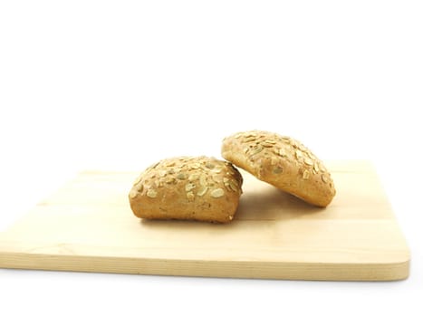 Bread with seeds isolated on a wooden board