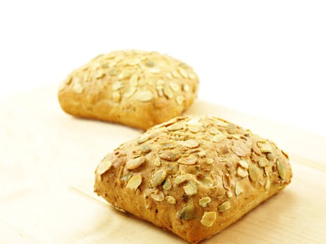 Bread with seeds isolated on a wooden board