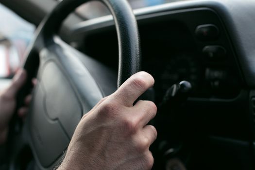  hand close up of a man driving a car
