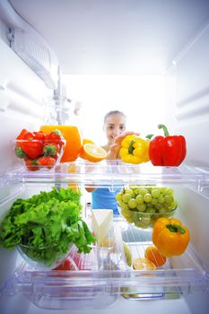 Woman reaching for food in refrigerator, view from inside