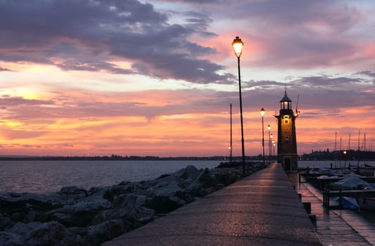 Amazing Sunrise at Desenzano del Garda with the marina and the old Lighthouse.