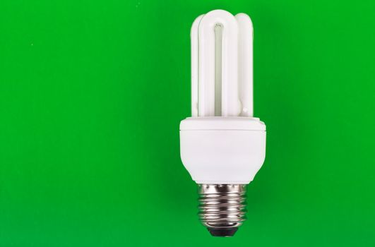 Energy saver bulb over green background