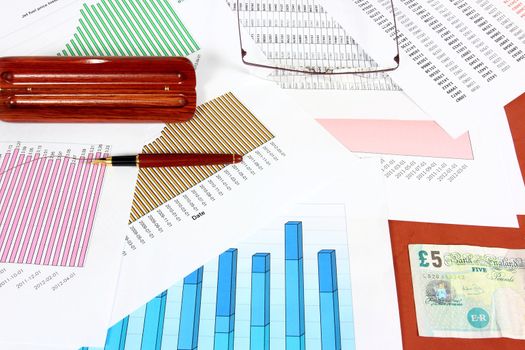 Business objects - fuel price charts, British pounds, ink pen and glasses. Financial concept.