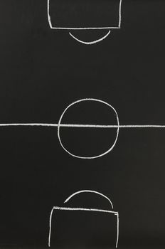 Top view of an empty soccer field sketched with white chalk on a black board.