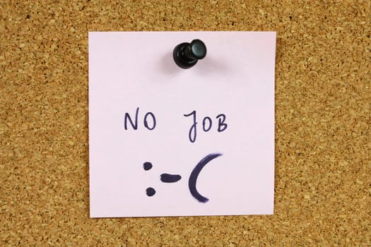 Pink small sticky note on an office cork bulletin board. Unemployment and job crisis concept. Looking for a new career.