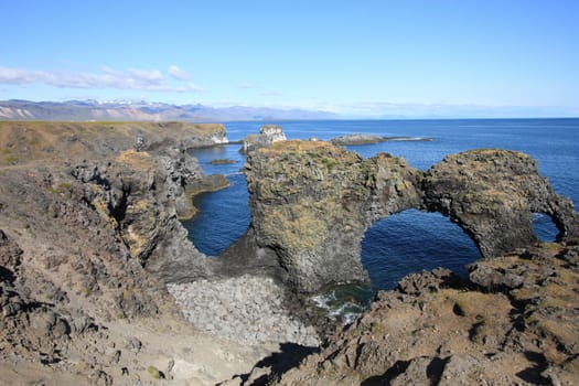 Amazing natural rock gate in Arnarstapi, Snafellsnes peninsula, Iceland. Faxafloi bay.