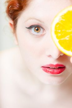 beautiful red hair and lips girl with orange on white background