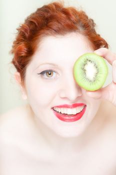 beautiful red hair and lips girl with kiwi on white background