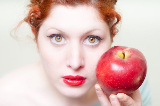 beautiful red hair and lips girl with apple on white background