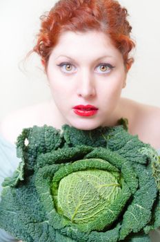 beautiful red hair and lips girl with savoy cabbage on white background