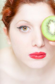 beautiful red hair and lips girl with kiwi on white background