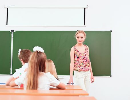 teacher stands in front of students in the class