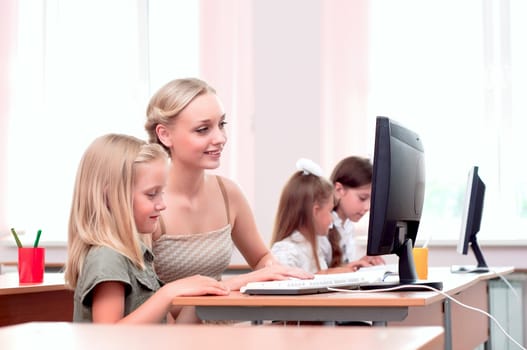 teacher explains the task schoolgirl at the computer, the new technologies in education