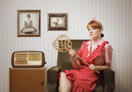 Ironic portrait of a housewife retro sitting in an armchair