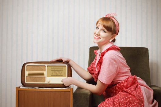 Old-fashioned young woman listening to the radio