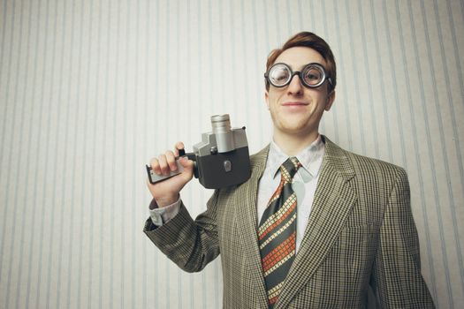 Nerdy young man with old fashioned cine camera