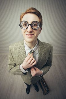 Nerdy old style salesman adjusting tie