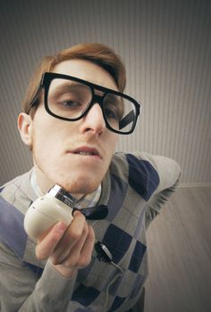 Nerd student shaving with vintage electric shaver